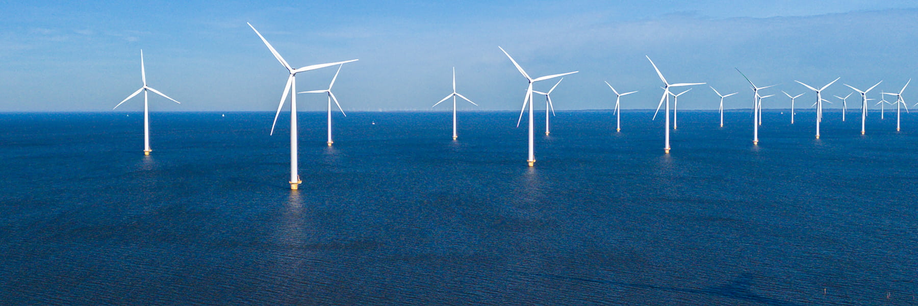 Offshore wind turbines in the ocean on a sunny day.